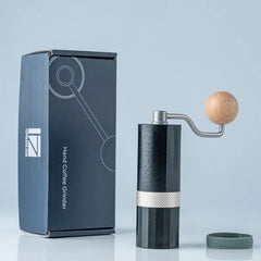 Black 1Zpresso Q-Air hand coffee grinder next to box and no-slip ring