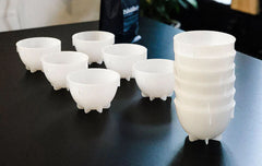 Barista Hustle plastic cupping bowls arranged on a black table