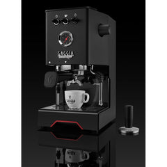 Black Gaggia Classic UP espresso machine with a white espresso cup on the drip tray and a tamper alongside.
