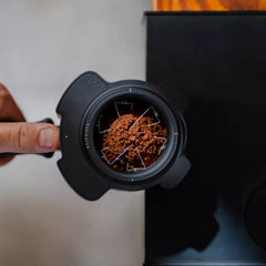 Puq Navigator WDT tool being used on top of portafilter with coffee grounds