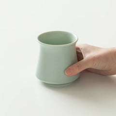 Green Origami Harmony Cup with hand