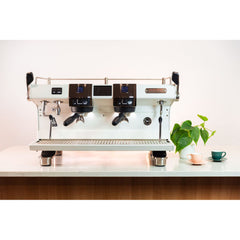 White Rancilio RS1  two group head espresso machine on bar with cups and plant