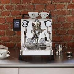 Rocket R58 TUNE espresso machine on a kitchen counter with cups on top and a milk jug beside it.