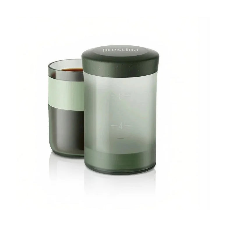 Wacaco Prestina in Sage Green portable coffee maker beside its coffee-filled cup.
