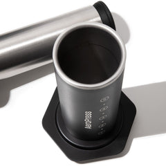 Close-up of the black AeroPress brewing chamber with its stainless steel interior and detached plunger.