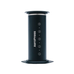 Black AeroPress Stainless Steel Coffee Press with the plunger fully inserted and numbered markings visible.