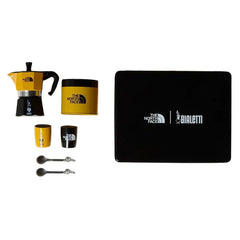 Bialetti x The North Face Adventure Set with moka pot, coffee tin, two cups, two spoons and black case on white.