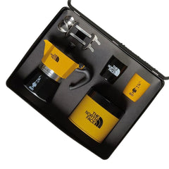 Angled view of the Bialetti x The North Face Adventure Set in its case, with moka pot, cups, spoons and coffee tin.