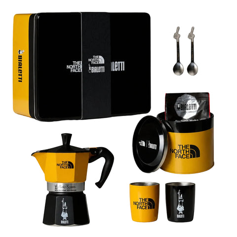 Bialetti x The North Face Adventure Set with moka pot, coffee tin, two cups, two spoons and black case on white.