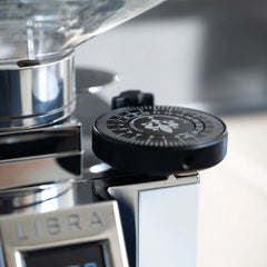 Close-up of the Eureka Mignon King Size Dial fitted beside the hopper on a chrome Mignon Libra grinder.
