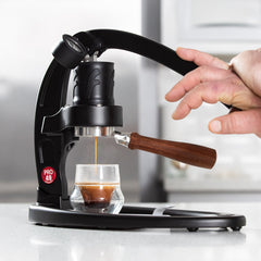 Flair 49 PRO Espresso Maker lifestyle shot with espresso glass and hand
