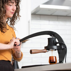 Woman using the Flair 58+ manual espresso maker for coffee