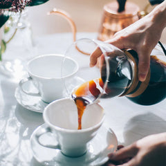 Hario Drip Pot Woodneck coffee brewer pouring coffee into cup