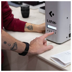 Nucleus Link Roaster on a white desk with hands pressing buttons