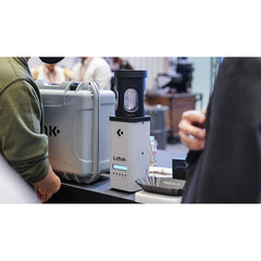 Nucleus Link Coffee Roaster on a demo bar with onlookers & coffee beans on the table