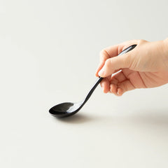 Origami ceramic cupping spoon in hand