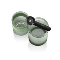 Overhead view of the Wacaco Prestina cup and brewing chamber with the coffee scoop resting across the rim.
