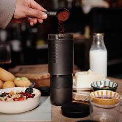 Close-up of a scoop adding ground coffee to the Wacaco Prestina brewing chamber.