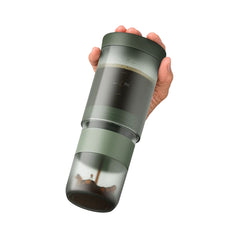 Hand pressing the Wacaco Prestina cap as brewed coffee flows into the attached cup.