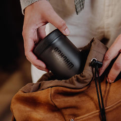 Packing the compact Wacaco Prestina coffee maker into a drawstring bag.