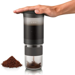Hand pressing the Wacaco Prestina’s top cap to release brewed coffee into the cup below.